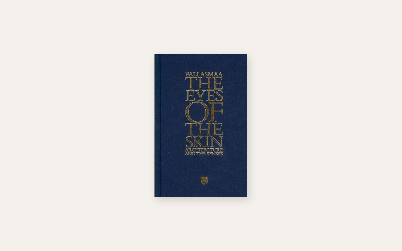 The cover of The Eyes of the Skin by Juhani Pallasmaa, gold lettering on navy cloth